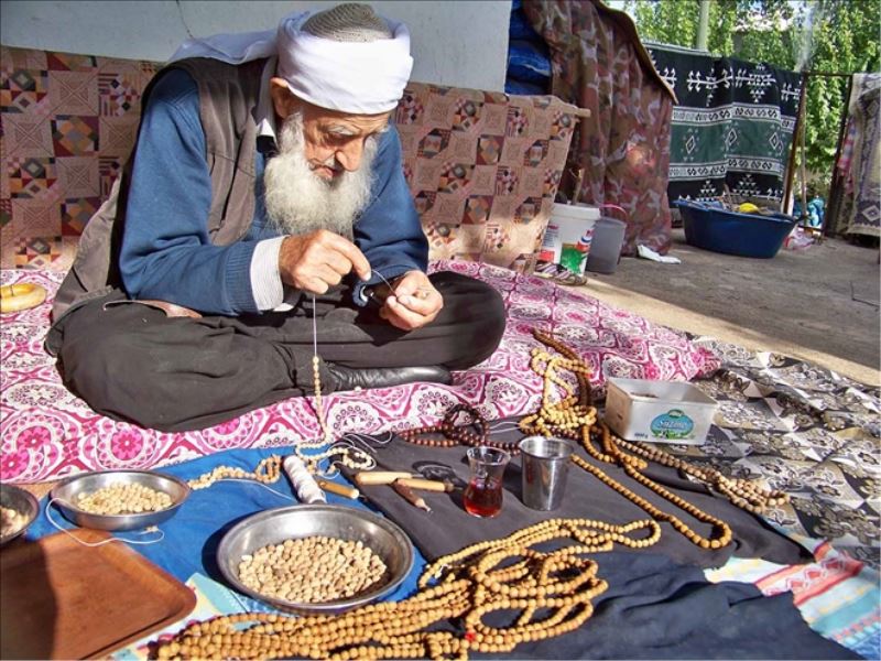 Zeytin çekirdeklerinden tesbih yapıyor